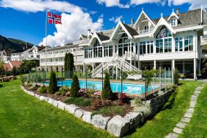 松达尔霍夫隆德峡湾酒店的一座白色的大建筑,前面设有一个游泳池