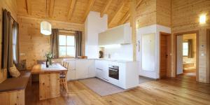 圣洛伦佐-迪塞巴托Chalet Oberguggenberg的一间厨房,配有白色家电和木制天花板