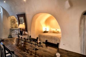 伊亚Heliophos Boutique Caves的一间卧室配有一张床和一张木桌