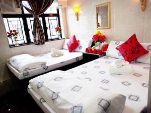 香港Germany Hostel Block D的配有红色和白色枕头的客房内的两张床