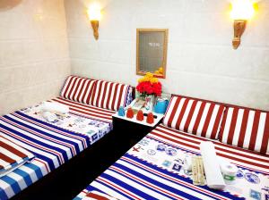 香港Germany Hostel Block D的一张带桌子和鲜花的房间里两张条纹床