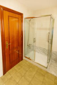 利亚内斯La capitana Llanes的浴室里设有玻璃门淋浴