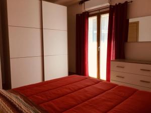 多尔加利CAV Mameli的一间卧室配有床、窗户和梳妆台