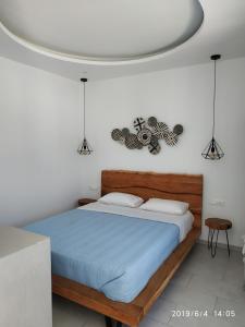 Vrisi/ MykonosNikos Rooms的一间卧室配有一张带蓝色棉被的床
