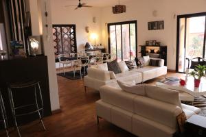 达喀尔Nyéléni maison sahel的一间带白色沙发的客厅和一间用餐室