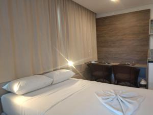 嘎林海斯港MARULHOS RESORT - STÚDIOS TEMPORADA的酒店客房,配有一张床和一张桌子及椅子