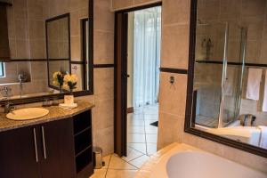 比勒陀利亚卡萨弗洛拉旅馆的带浴缸、水槽和淋浴的浴室