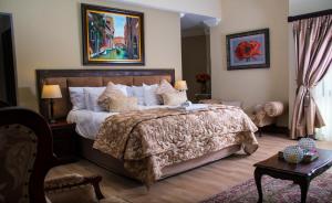 比勒陀利亚卡萨弗洛拉旅馆的一间卧室配有一张大床和一张桌子