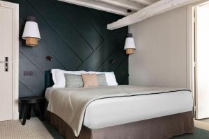 巴黎巴斯提尔斯佩利亚酒店的一间卧室设有一张大床和绿色的墙壁