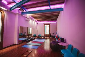 巴塞罗那兰巴拉斯公寓式酒店的健身房设有地板上的瑜伽垫和紫色墙壁