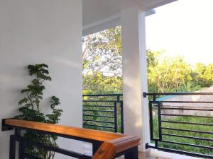 安达Za Priscila Tourist Inn的木制长凳,位于带窗户的阳台
