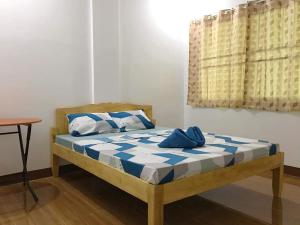 安达Za Priscila Tourist Inn的一间卧室配有蓝色和白色床单