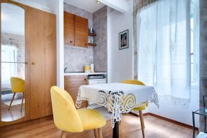 科米扎库尔基斯住宿加早餐旅馆的厨房配有桌子和黄色椅子