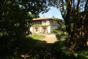 MomuyRicouch, chambre d'hôtes et permaculture的一座古老的房子被树所环绕