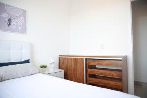 迪亚曼蒂纳Apartamento novo 3 quartos的一间卧室配有一张床和一个木制梳妆台