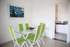 迪亚曼蒂纳Apartamento novo 3 quartos的一间设有玻璃桌和绿色椅子的用餐室
