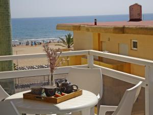 洛斯马蒂雷斯VORA GANDIA BEACH - Alquiler Familias的海滩景阳台配有桌椅