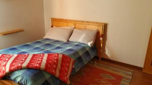 圣奥莫波诺伊马加I Tre Ciliegi Apartment的一间卧室配有一张带彩色毯子的床