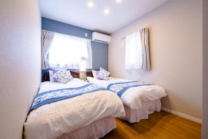 富士河口湖villa hanasaku 富士河口湖町A棟的带2扇窗户的客房内的2张床