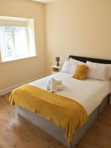 阿斯隆Glen Abhainn Standard Budget Accommodation的一间卧室配有一张带黄色床单的大床和窗户。
