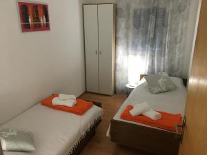 奥利布岛Apartment Milin的一间卧室配有两张床,提供橙色和白色的毛巾