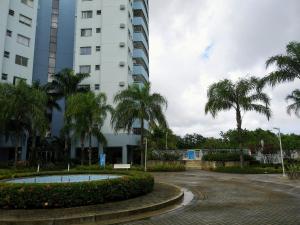 里约热内卢Apartamento Vila DR - Barra da Tijuca,prox Jeunesse,Arenas,Rio Centro,praias, Shopping的一座棕榈树建筑前方的建筑