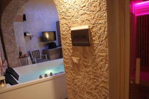 韦列Afrodite Luxury Suite的一间带电视、浴缸和一个房间的浴室