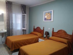 奥卡尼亚Hostal Ávila的酒店客房设有两张床和盥洗盆