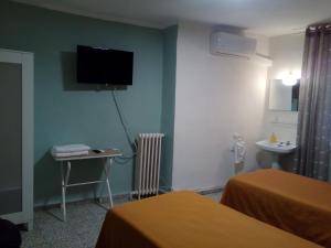 奥卡尼亚Hostal Ávila的酒店客房设有壁挂式电视和桌子。