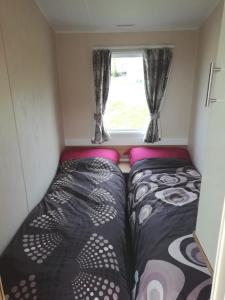 斯沃尼奇Swanage Bay View caravan的小房间设有两张床和窗户