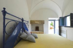 斯佩基亚Masseria delle Pecore的一间卧室配有蓝色的床和枕头