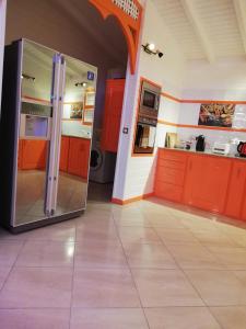 大博格Résidence Clémentine Villa Passion的厨房配有橙色橱柜和大冰箱