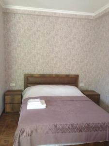 SuramiResort Hotel surami的一间卧室配有一张带紫色床罩的床