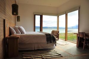 纳塔列斯港Hotel Simple Patagonia的一间卧室配有一张床,享有水景