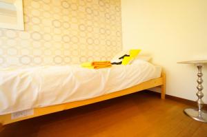 高山Takayama - Apartment / Vacation STAY 34381的一间卧室配有一张带白色床单和一张桌子的床。