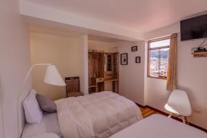库斯科Cozy Room Cusco的一间卧室设有两张床和窗户。