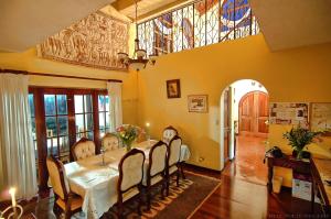 圣何塞卡里阿利住宿加早餐旅馆的一间带桌椅和窗户的用餐室