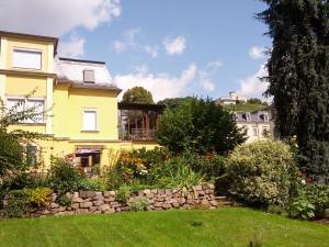 拉德博伊尔Ferienwohnung unterm Wasserturm的黄色的房子,前面有一个花园