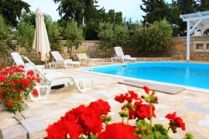 帕科坦BUNGALOW VICE with pool的一个带白色椅子和红色鲜花的游泳池