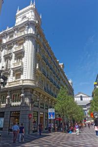 马德里Arenal Suites Puerta del Sol的一座城市街道上带钟楼的大型建筑