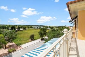 ImmokaleeAve Maria Rentals Fl的阳台设有蓝色和白色的楼梯和绿色的田野。
