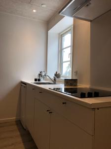 吉弗Hedegaard Holiday Apartments的白色的厨房设有水槽和窗户