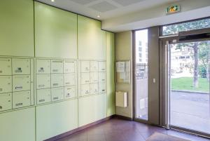 德希内斯·尚皮埃Appart'cosy Lyon Est的一间设有储物柜的房间和一扇门,位于大楼内