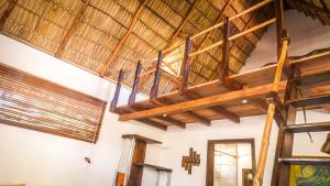 波波约Vibra Guesthouse Popoyo的客房拥有带木梁的大型木制天花板。