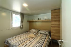 耶泽拉MOBIL HOMES MALUFI 266的一间卧室配有一张床,床上有毛巾