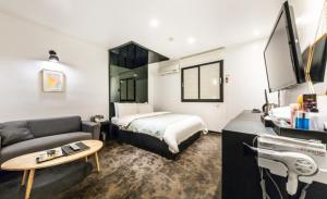 首尔Gugi Motel的酒店客房,配有床和沙发