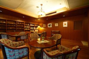 日田市风早酒店的一间图书馆,里面摆放着椅子和桌子
