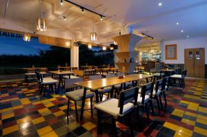 坎古寇阿迪冲浪酒店的一间设有桌椅的餐厅,位于色彩缤纷的楼层