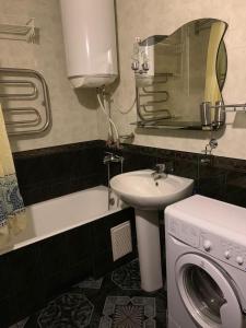 敖德萨159 Проспект Добровольского Большая 3-х комнатная квартира в Одессе的一间带水槽和洗衣机的浴室
