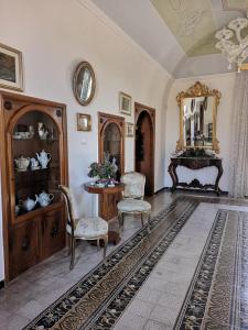 焦维纳佐B&B villa Maria的客厅配有桌椅和镜子